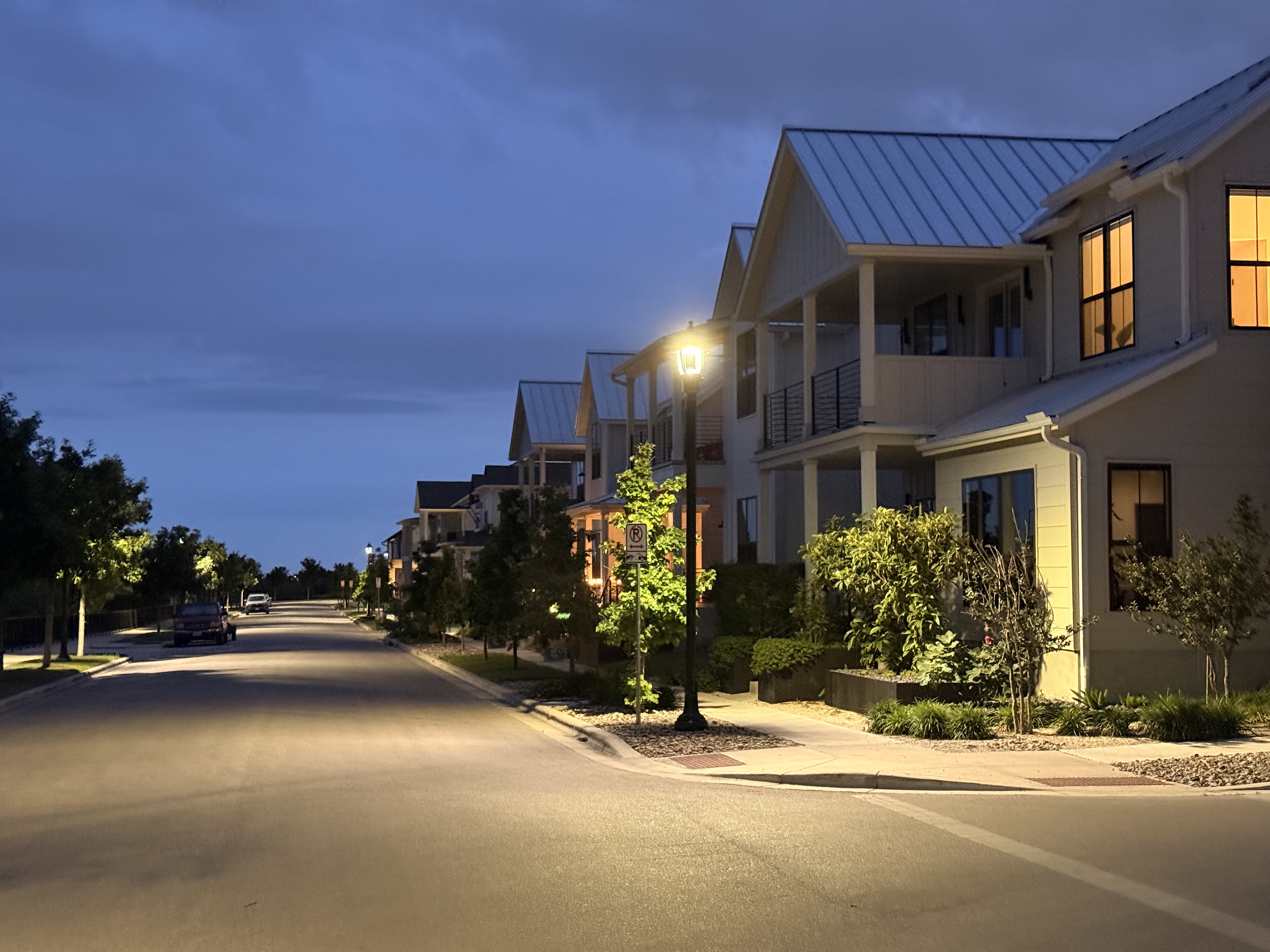 Mueller neighborhood residential street at dusk with townhomes and street lights